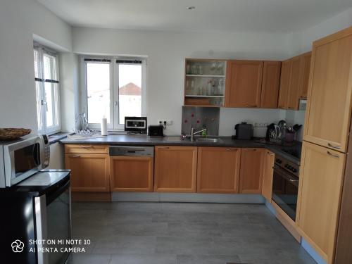 a kitchen with wooden cabinets and a counter top at Casa Bianka in Fridolfing