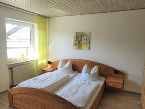 1 dormitorio con 1 cama con sábanas y almohadas blancas en Landgasthof Braun, en Mindelstetten