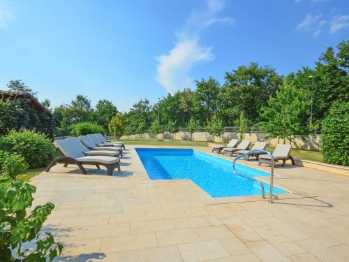 a row of lounge chairs next to a swimming pool at Villa Kate by Interhome in Sveti Petar u Šumi