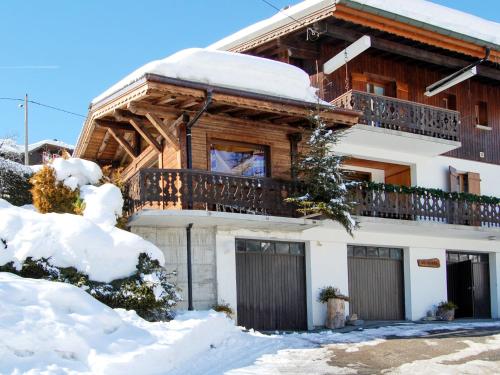 une cabane en rondins dans la neige avec un balcon dans l'établissement Apartment Le Tetras-1 by Interhome, à Morzine