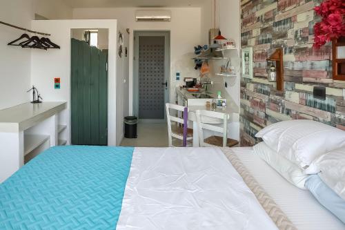 a bedroom with a white bed and a kitchen at Pefkos Eye in Pefki Rhodes