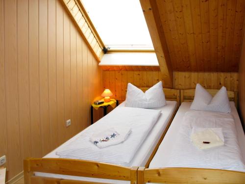 two beds in a small room with a window at Apartment Old Hüsung - MUZ320 by Interhome in Mirow