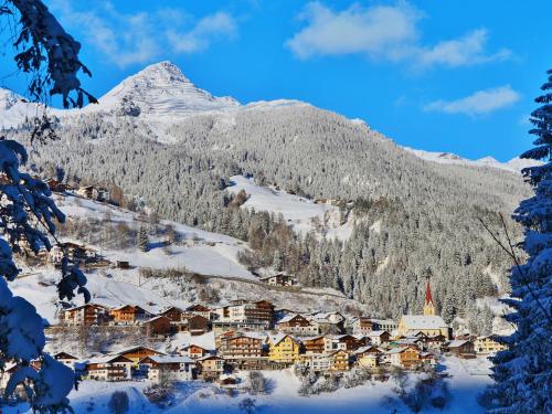 une ville dans la neige avec une montagne en arrière-plan dans l'établissement Apartment Sabine - KPL671 by Interhome, à Kappl