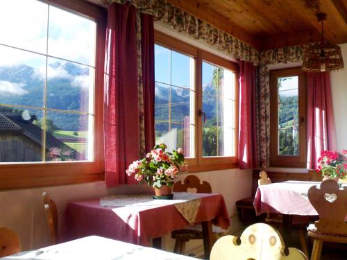 a dining room with two tables and two windows at Apartment Zollerhof - OLA192 by Interhome in Valdaora di Sotto