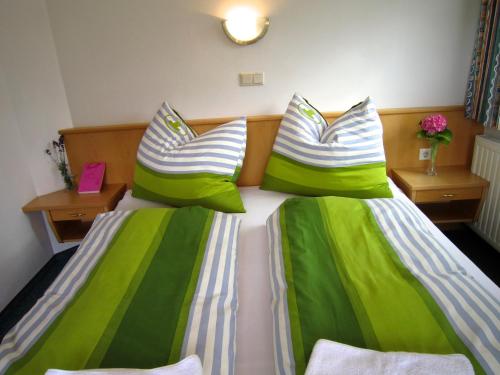a bedroom with two beds with green and white sheets at Apart-Pension Seiwald in Wagrain