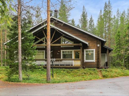 uma cabana de madeira na floresta com um alpendre em Holiday Home Artturi by Interhome em Levi