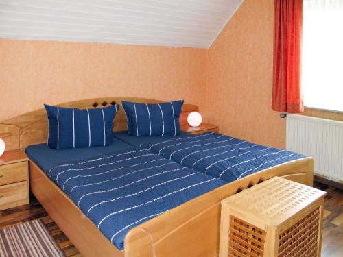 ein Schlafzimmer mit einem großen Bett mit blauen Kissen in der Unterkunft Apartment Hannemann-2 by Interhome in Schillig
