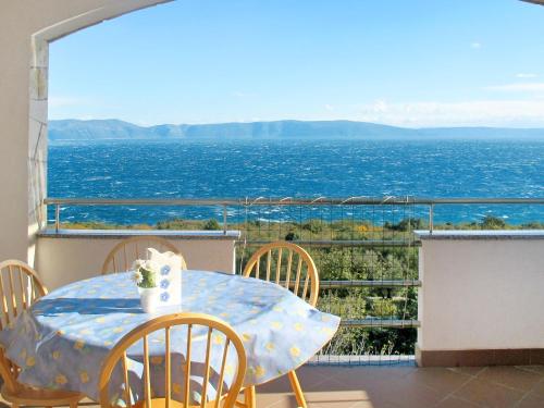 a table and chairs on a balcony with a view of the ocean at Apartment Blazina-1 by Interhome in Ravni