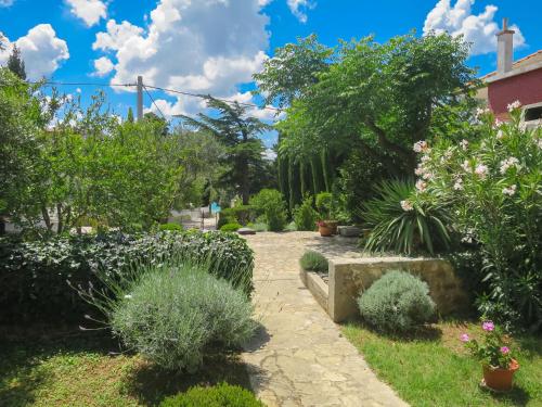 a garden with plants and flowers on a sunny day at Apartment Gottwald - SRD305 by Interhome in Starigrad