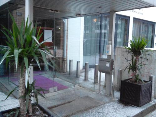 a lobby of a building with two potted plants at City-Apartments Hamburg in Hamburg