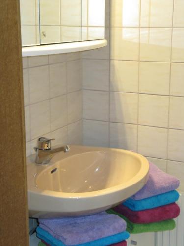 a bathroom with a sink and a pile of towels at Ferienwohnung Salzmann in Innsbruck