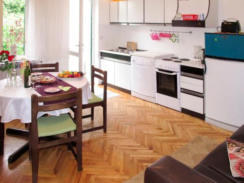 a kitchen with a table and white appliances at Apartment Branka-1 by Interhome in Mošćenice