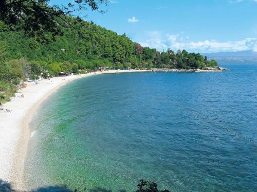 a beach with a group of people in the water at Apartment Branka-1 by Interhome in Mošćenice
