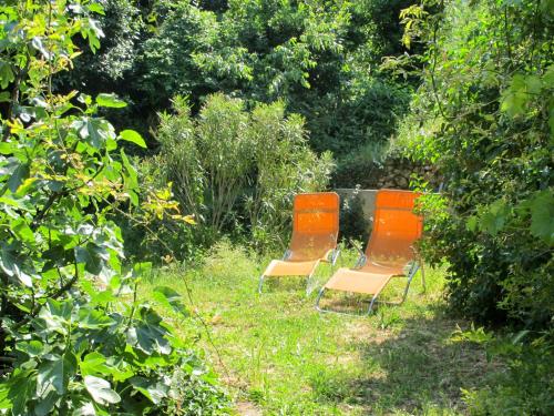 two orange chairs sitting in the middle of a garden at Apartment Branka - MOD205 by Interhome in Mošćenice