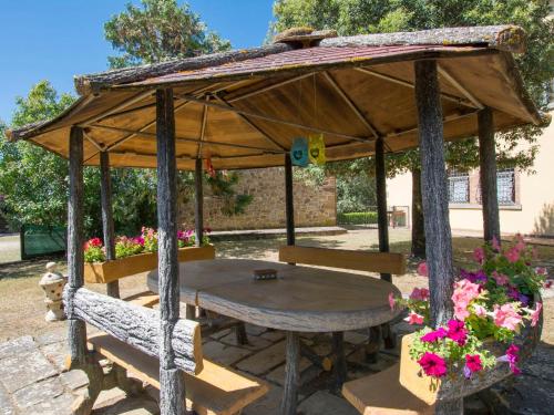 un pabellón de madera con mesa y bancos en Holiday Home Le Terrazze by Interhome, en Civitella in Val di Chiana