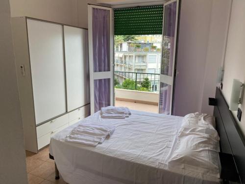 a bedroom with a bed and a large window at Hotel Nuovo Metropol in Albissola Marina