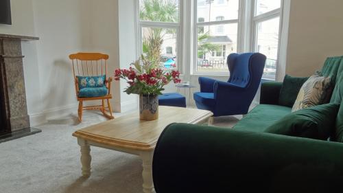a living room with a couch and a table and chairs at Snowdon Retreat Villa by Seaside Llandudno in Llandudno