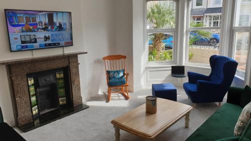 a living room with a fireplace and a tv at Snowdon Retreat Villa by Seaside Llandudno in Llandudno