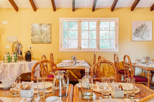 a dining room with tables and chairs and a window at Quinta da Moscadinha in Camacha