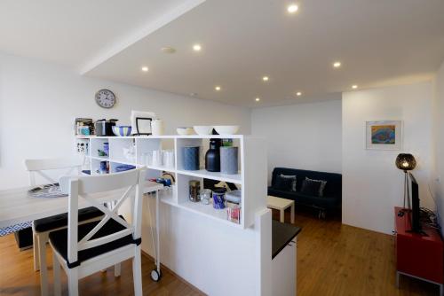 a living room with a white counter and a chair at Bellevue Boulevard 32 in Vlissingen