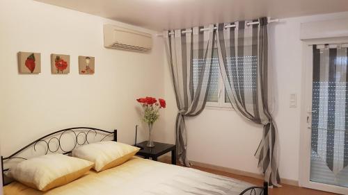 een slaapkamer met een bed en een vaas met bloemen bij Maison avec vue in Les-Pennes-Mirabeau