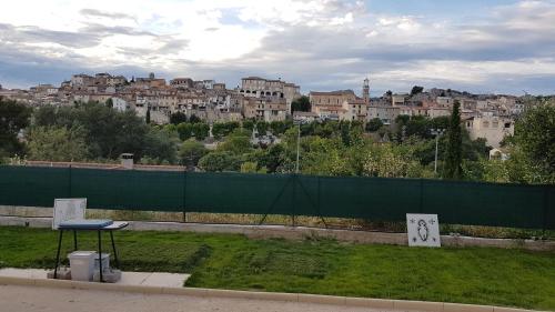 a bench in a park with a fence and buildings at Maison avec vue in Les-Pennes-Mirabeau