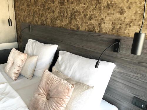 a bed with white pillows and a wooden headboard at Superb Design Villa Medulin in Medulin