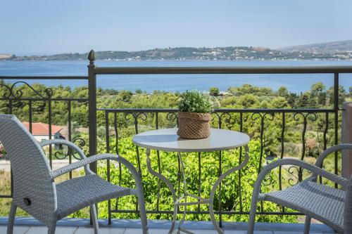 a table and chairs on a balcony with a view of the water at Panorama Fanari studios and apartments in Argostoli