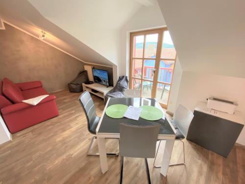 a dining room with a table and chairs and a red couch at Ferienwohnung Denise in Rötz