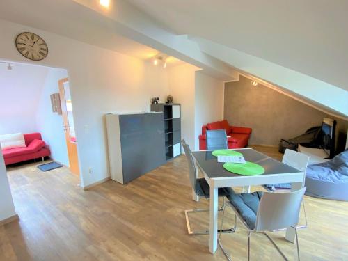 a dining room and living room with a table and chairs at Ferienwohnung Denise in Rötz