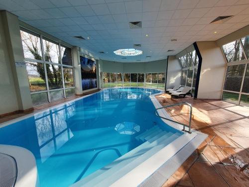 - une grande piscine d'eau bleue dans une maison dans l'établissement Fletcher Hotel Restaurant Dinkeloord, à Beuningen