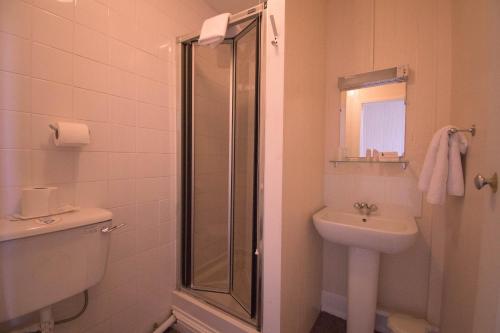 a bathroom with a sink, toilet and shower at Pinegrove Hotel in Carlisle
