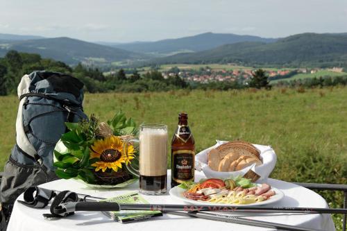a table with a plate of food and a bottle of beer at Landhotel Gruber in Waldmünchen