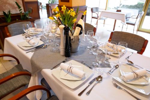 a table with wine glasses and flowers on it at Business Hotel Vega Wrocław in Wrocław