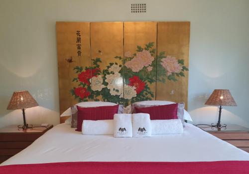 a bedroom with a white bed with two lamps at Slaley Country House in Stellenbosch