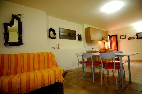 a living room with a couch and a table and chairs at Il Sogno di Alghero - Adults Only in Alghero