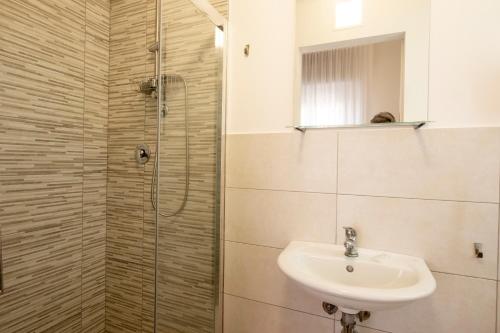 a bathroom with a sink and a shower at Hotel Lexington in Rimini