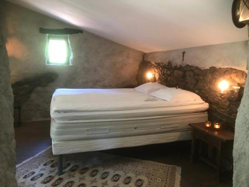 - une chambre avec un grand lit dans un mur en pierre dans l'établissement L'abri la Vall, à Sorède