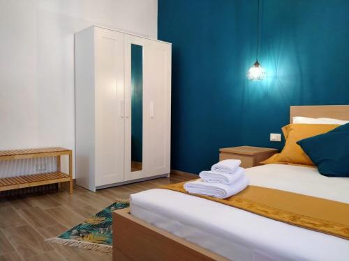 une chambre avec un lit et un mur bleu dans l'établissement AL CIVICO 1 APARTMENTS, à Trapani