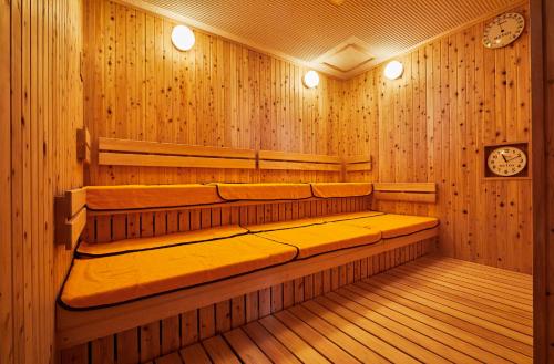 a sauna with wood paneling and two clocks on the wall at Hotel Emion Kyoto in Kyoto