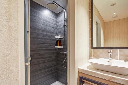 a bathroom with a sink and a shower at Hotel Emion Kyoto in Kyoto