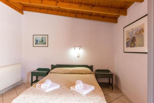 a bedroom with a bed with two towels on it at Philoxenia Apartments in Panormos Rethymno