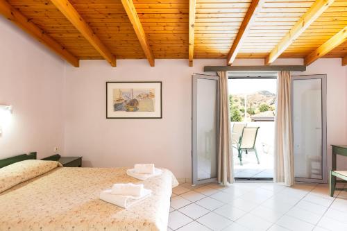 1 dormitorio con 1 cama grande y patio en Philoxenia Apartments, en Panormos Rethymno