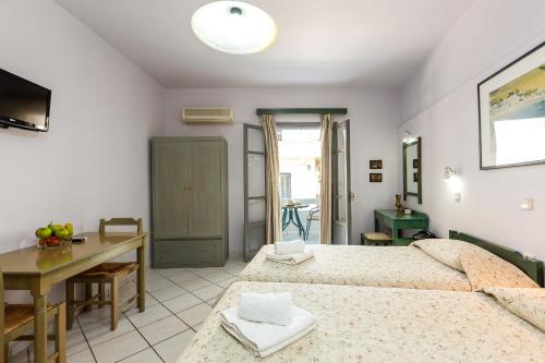 a bedroom with a bed and a table and a desk at Philoxenia Apartments in Panormos Rethymno