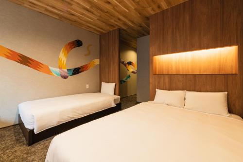 Een bed of bedden in een kamer bij GRAND BASE Shianbashi