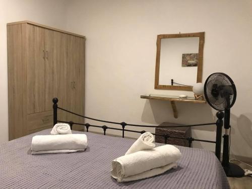 a bedroom with two towels on a bed with a fan at Sarris Ligaridia Apartments in Naxos Chora