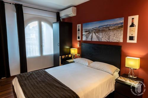 ein Schlafzimmer mit einem großen Bett und einem Fenster in der Unterkunft Agroturismo Valdelana in Elciego