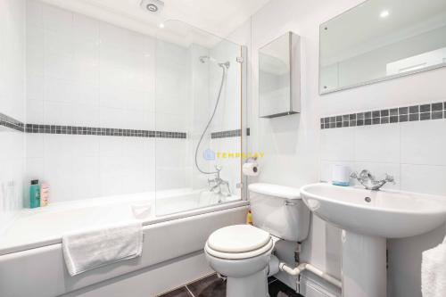 a white bathroom with a toilet and a sink at PERFECT SPOT IN CENTRAL WINDSOR & FREE PARKING! in Windsor