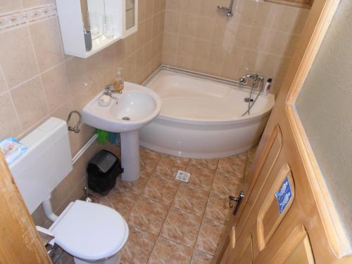 a bathroom with a tub and a sink and a toilet at Vila Busteni DORA, locatie superba strada Grivitei 36 in Buşteni