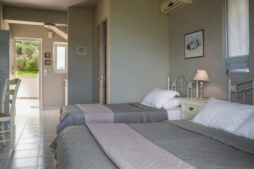 a bedroom with two beds and a table and chairs at Panorama Fanari studios and apartments in Argostoli